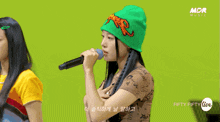 a woman singing into a microphone with the words fifty fifty live on the bottom right