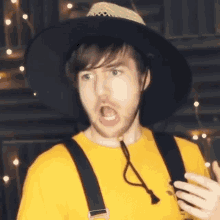 a man wearing a hat and suspenders is making a funny face .