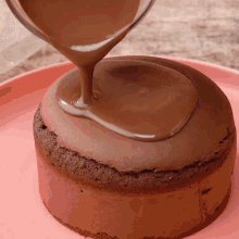 a chocolate cake is being poured with chocolate sauce