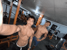 two muscular men pose for a picture in a gym