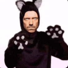 a man in a cat costume with paws on his arms