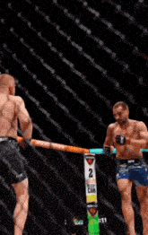 two men are fighting in a boxing ring with a sign that says 2