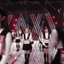 a group of young women are walking on a stage and one of them has a name tag that says ' ao ' on it