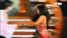a blurry picture of a woman in a pink dress and a man in a black shirt .