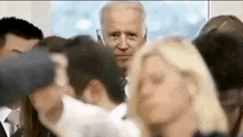 a man in a suit is standing in a crowd of people .