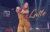 a woman in a leopard print outfit is singing into a microphone on stage .