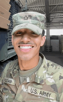 a man in a u.s. army uniform is smiling and wearing a hat