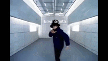 a man in a black top hat is dancing in a hallway with erwinsmith written on the wall behind him