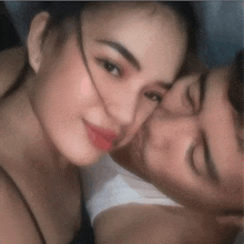a man is kissing a woman on the forehead in a blurry photo