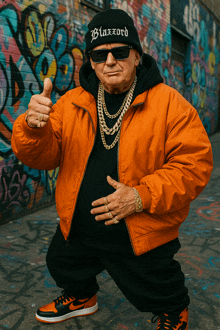 a man wearing an orange jacket and a black beanie with blazord on it