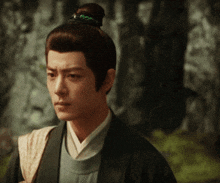 a man with a bun on his head is wearing a black jacket