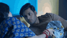 a man and a woman are laying on a bed and the woman is holding the man 's arm