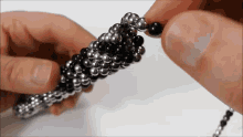 a close up of a person holding a bunch of beads