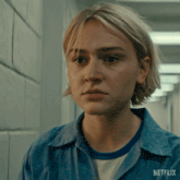 a woman in a blue shirt with netflix written on the bottom right
