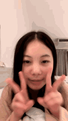 a young woman is making a peace sign with her fingers