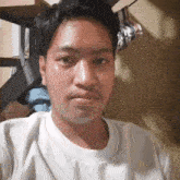 a man wearing a white shirt is taking a selfie