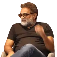 a man with a beard and glasses is sitting in a chair