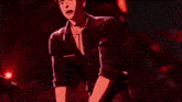 a man in a black suit is pointing at something in a video game .