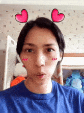 a woman wearing a blue shirt has hearts on her ears