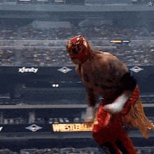 a wrestler is dancing in front of a sign for xfinity