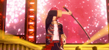 a man is holding a sword on a stage with a red background .