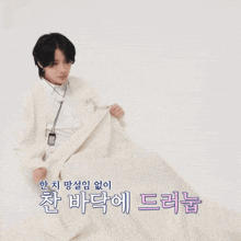 a person wrapped in a white blanket with chinese writing on the bottom