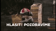 a cartoon character is holding a book in front of a pile of books and says , `` hlasite pozdravime '' .