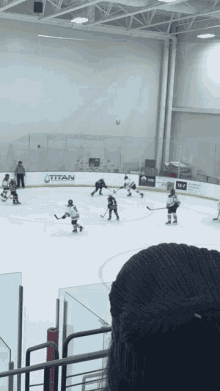 a hockey game is being played in a stadium with a titan advertisement on the wall