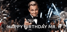 a man in a tuxedo is holding a glass of wine and toasting with the words `` happy birthday mr. k '' .