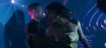 a woman in a green dress is dancing with a man in a black shirt
