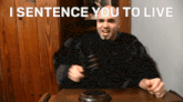 a man sitting at a table with a judge 's gavel and the words " i sentence you to live "
