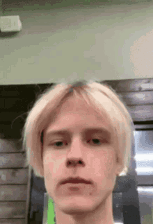a man with blonde hair looks at the camera