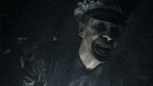 a close up of a man 's face with a hat that says ' a ' on it