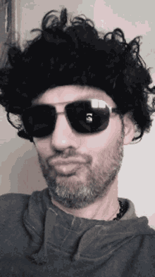 a man wearing sunglasses and a wig with a skull on it