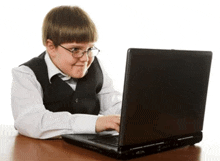 a young boy wearing glasses is using a laptop