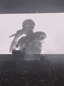 a man is singing into a microphone in front of a large crowd