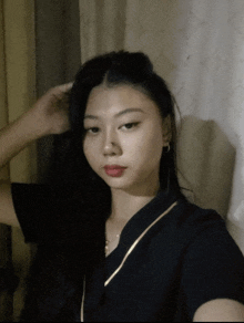 a woman in a black shirt is taking a picture of herself