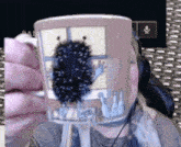a person is holding a mug with a picture of a monster on it in front of their face