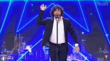 a man singing into a microphone with the word talent on the bottom right