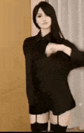 a woman in a black dress and suspenders is dancing in a room .