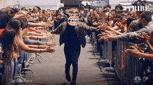 a man with a skull on his head is walking through a crowd