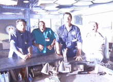 a group of men are standing around a counter and one of them has a badge that says ' emergency services ' on it