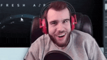 a man wearing headphones is smiling in front of a screen that says fresh air