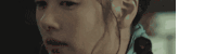a close up of a person 's face in a dark room with a black background .