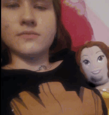 a woman is holding a stuffed doll while wearing a black shirt