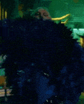 a woman in a blue feathered coat is walking down a street