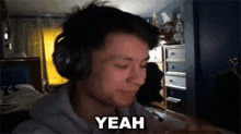 a man wearing headphones is saying yeah in a dark room