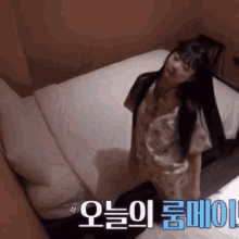 a woman is standing on a bed with korean writing on the bottom