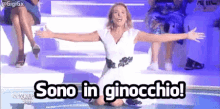 a woman in a white dress is kneeling down with her arms outstretched and the caption sono in ginocchio