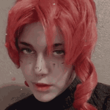 a close up of a person wearing a red wig and a nose ring .
